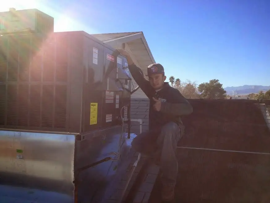 HVAC technician performing Air Duct Cleaning on a rooftop unit in Eldersburg